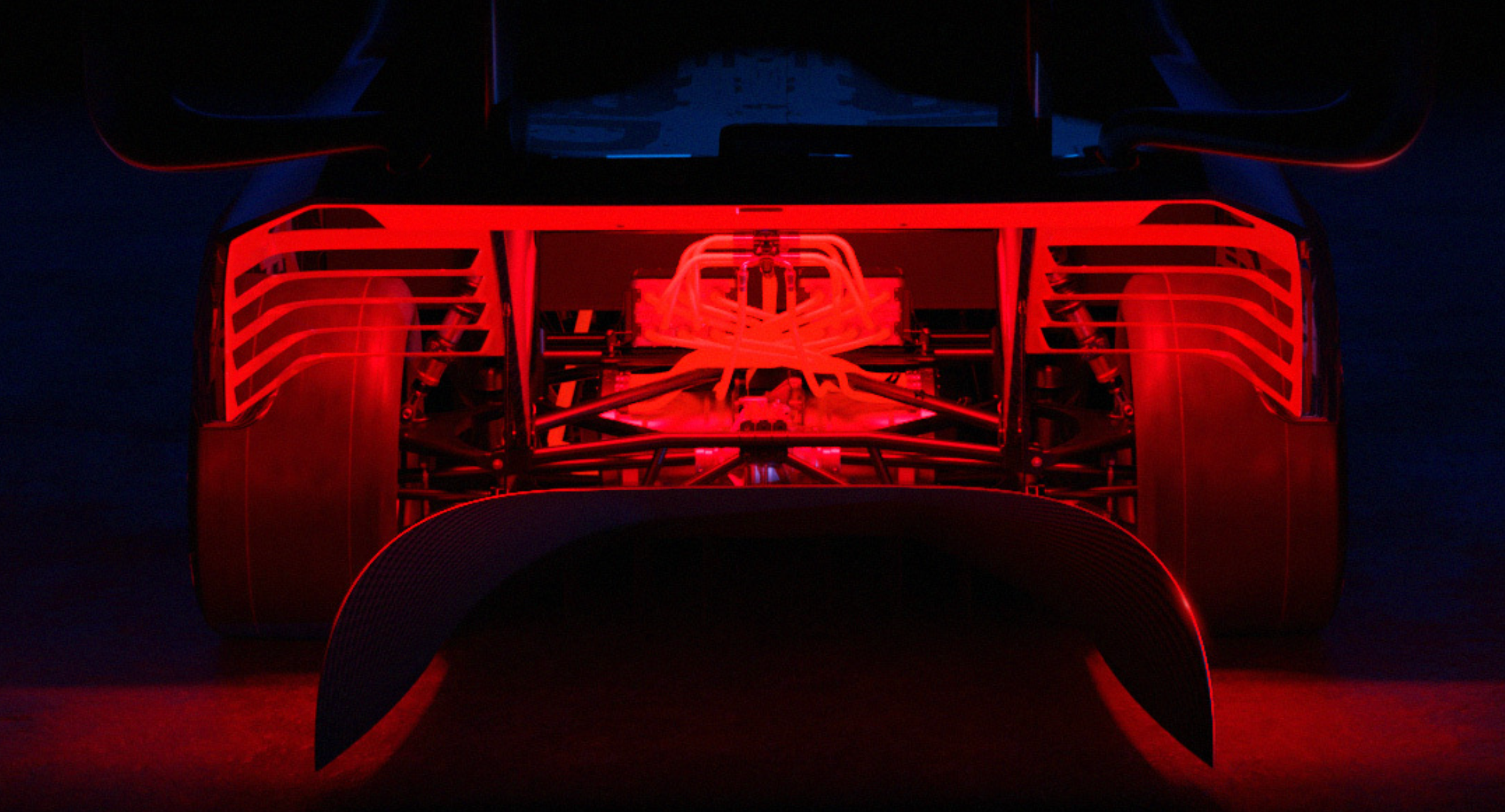 A portion of the modified aerodynamics of Ford's F-150 Lightning SuperTruck are teased with red light