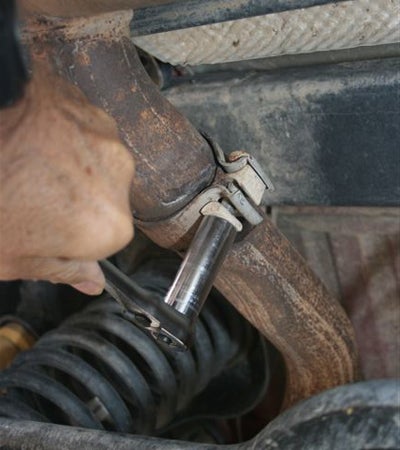 Using a 15mm deep socket, loosen the OEM exhaust clamp at the mufflers inlet.