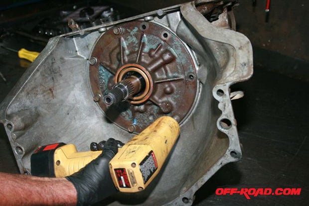 Using a Snap-On cordless electric impact wrench, the tech is removing the fluid pump bolts from the transmission case.