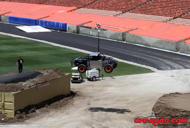 Robby Gordon looks on as Justin Lofton launches over the large gap.